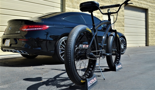 A bike parked next to a car