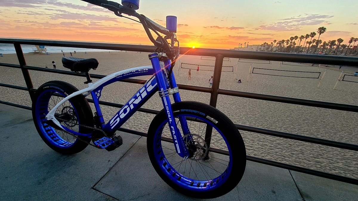 A picture of electric bike in blue color at a sun set