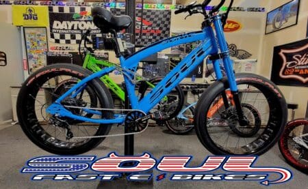 Blue electric bike displayed in showroom.