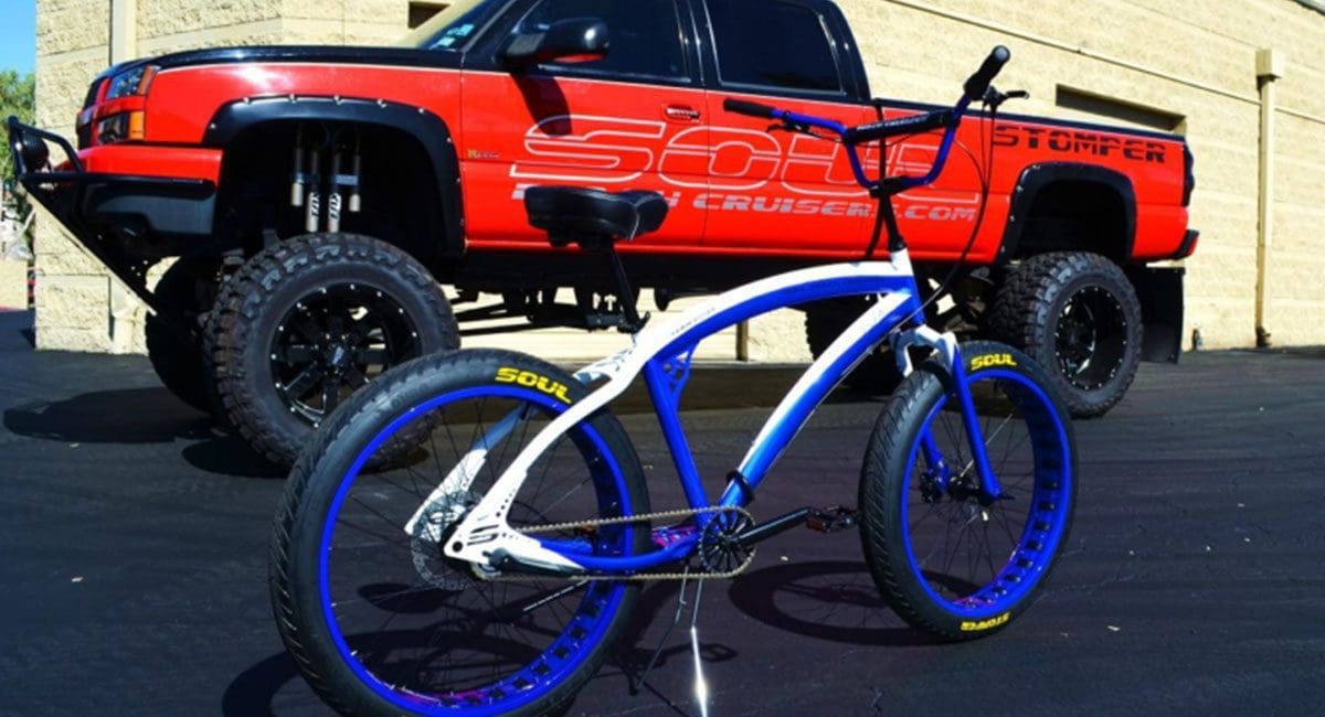 A blue and white SOULFAST EBIKES bike parked in front of a truck.