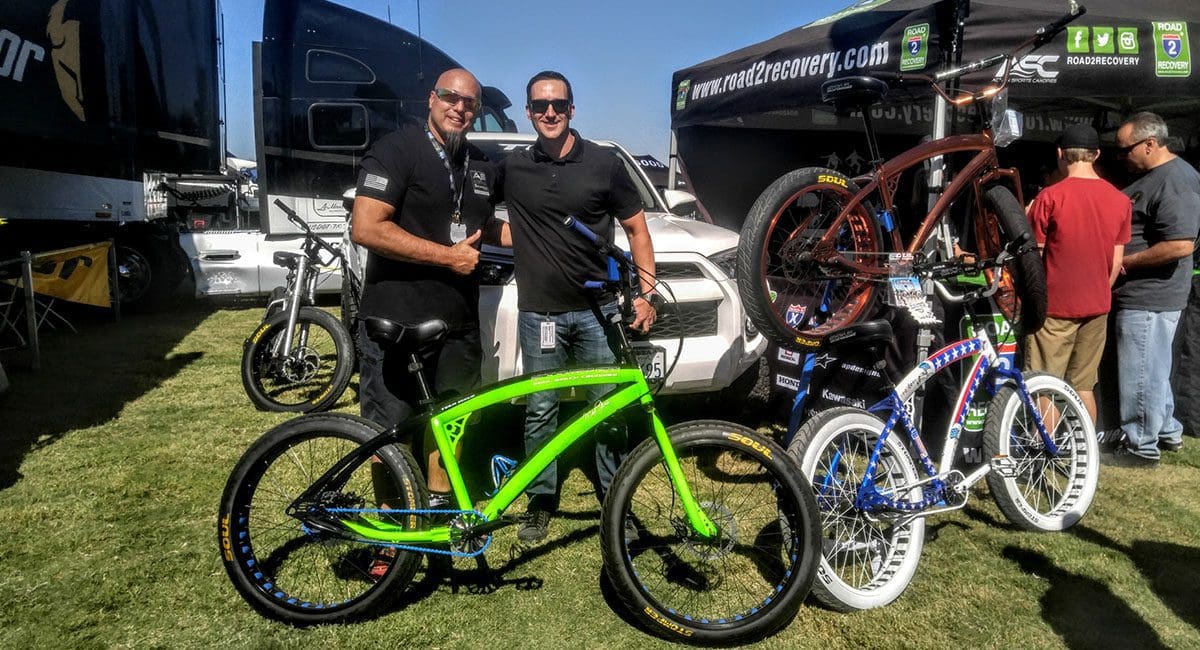 Two men standing next to SoulFast e-bikes at a bike show.