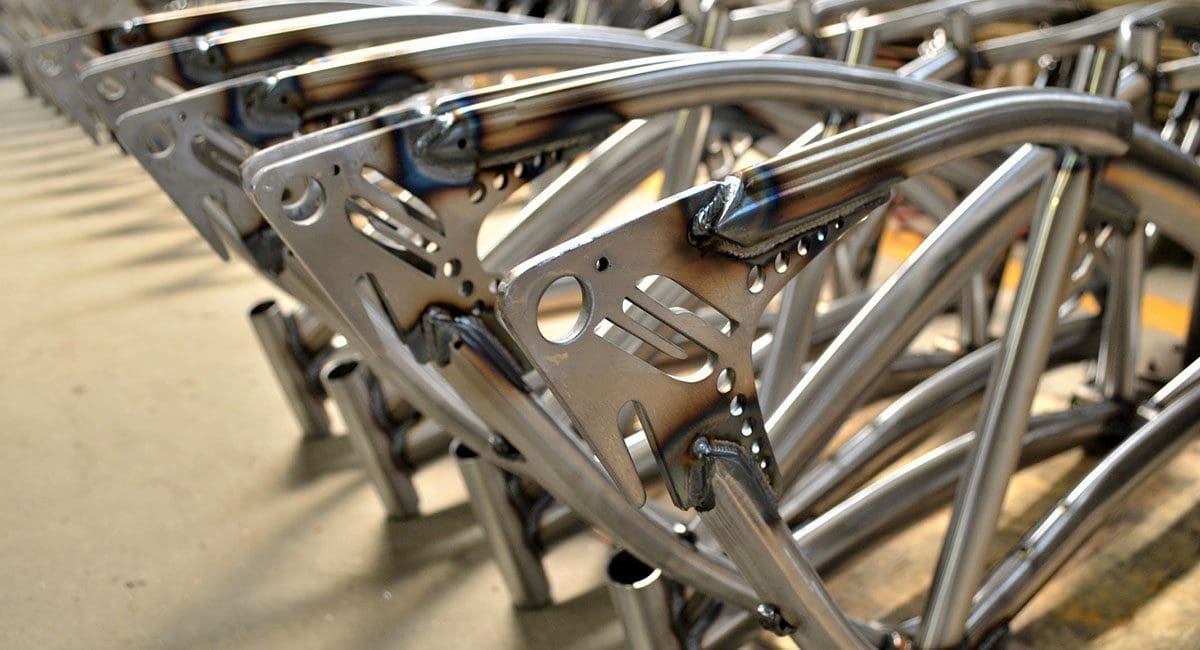 A row of metal SOULFAST EBIKES frames in a factory.
