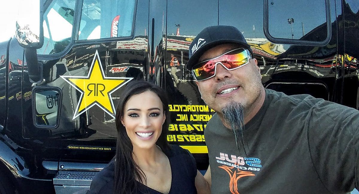 A man and woman posing for a selfie in front of a semi truck, showcasing the excitement of enjoying their SOULFAST EBIKES.