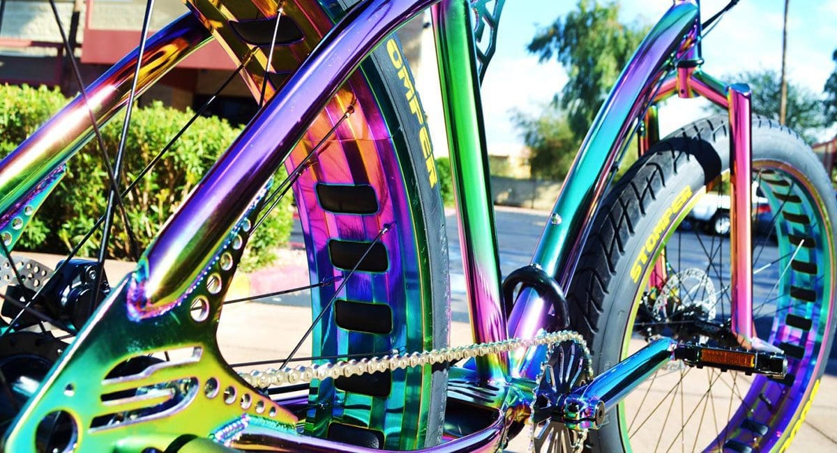 A rainbow colored SOULFAST bike parked on the side of the road.