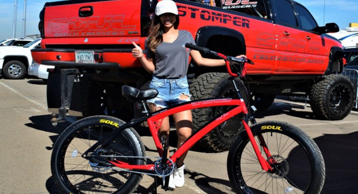 A woman standing next to a red bike