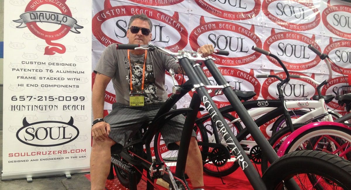 A man posing next to a chopper bike from SOULFAST EBIKES.