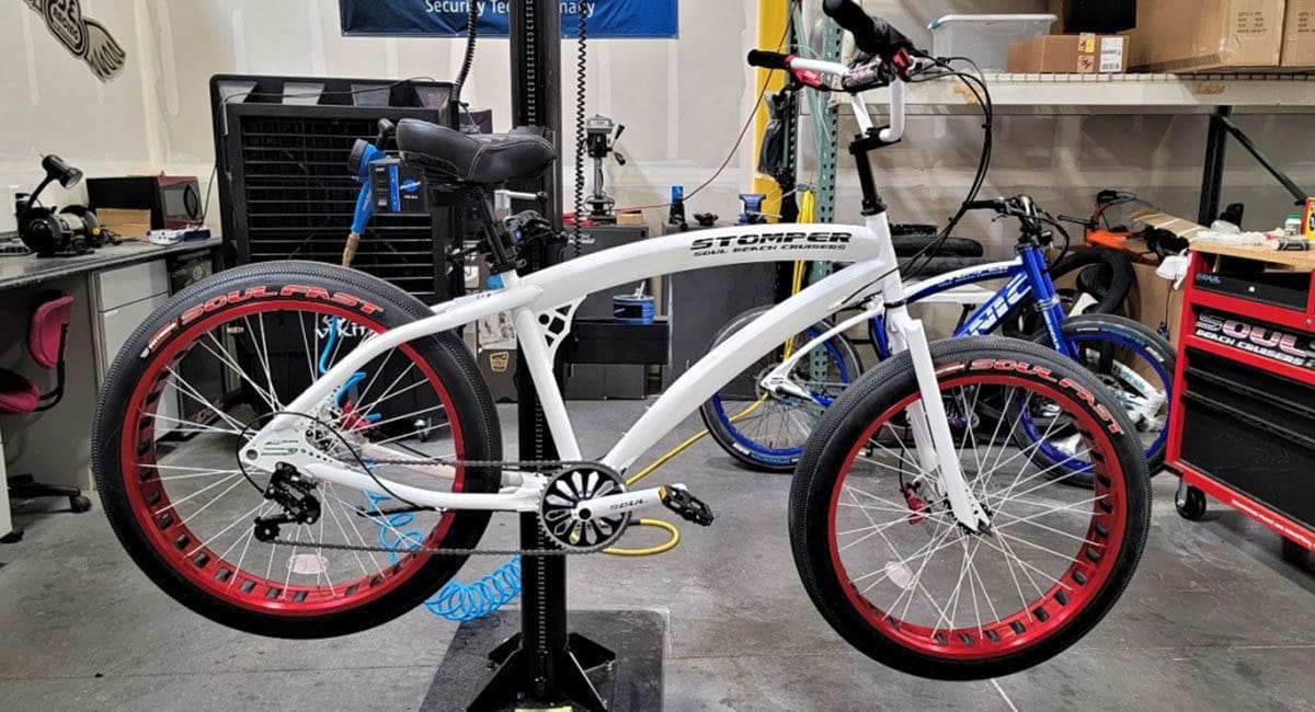 A white SOULFAST EBIKES bike with red rims in a garage.