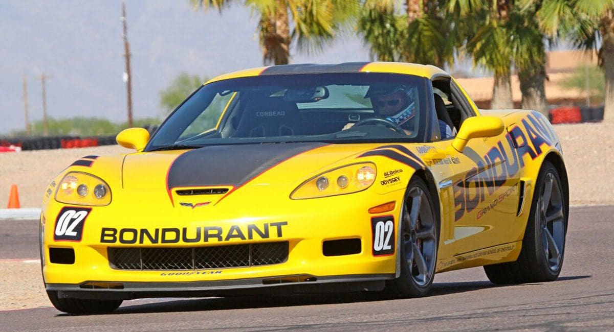 A yellow corvette is driving on a race track, showcasing the exhilaration and speed reminiscent of SOULFAST EBIKES.