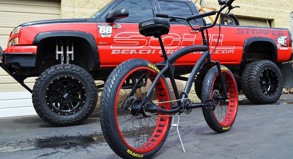 A Pedal Stomper bike parked in front of a truck.