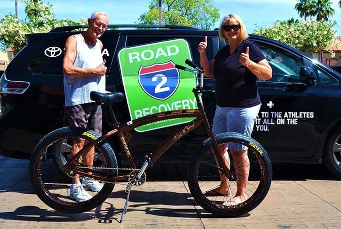 Two people standing next to a van with a bike in front of it, featuring SOULFAST EBIKES.