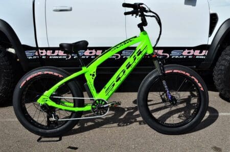 A neon green bicycle parked in front of a white van.