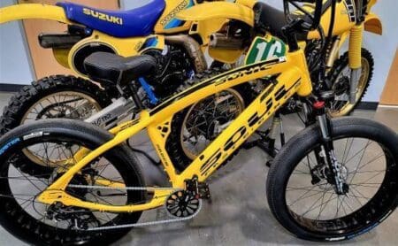 A yellow bike parked next to other bikes.