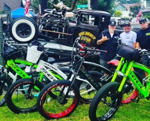 A group of men sitting next to bicycles.