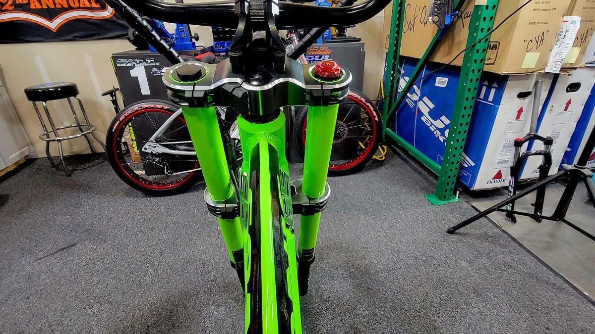 A neon green bike is sitting in the middle of a room.