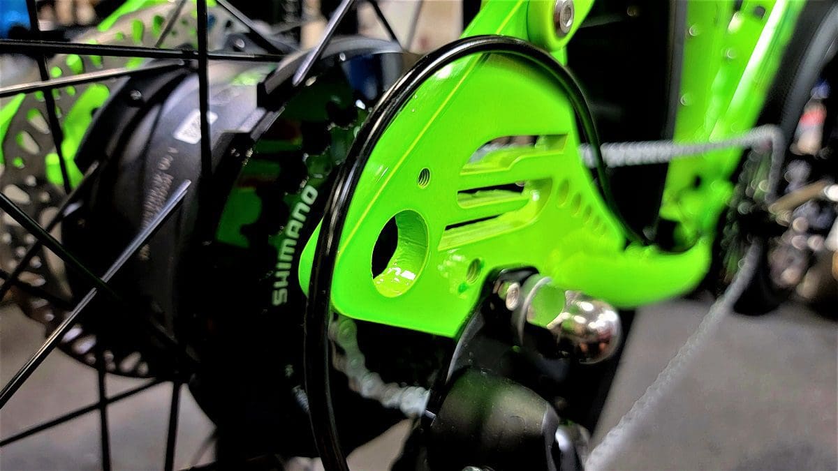 A close up of the front end of a green bicycle.