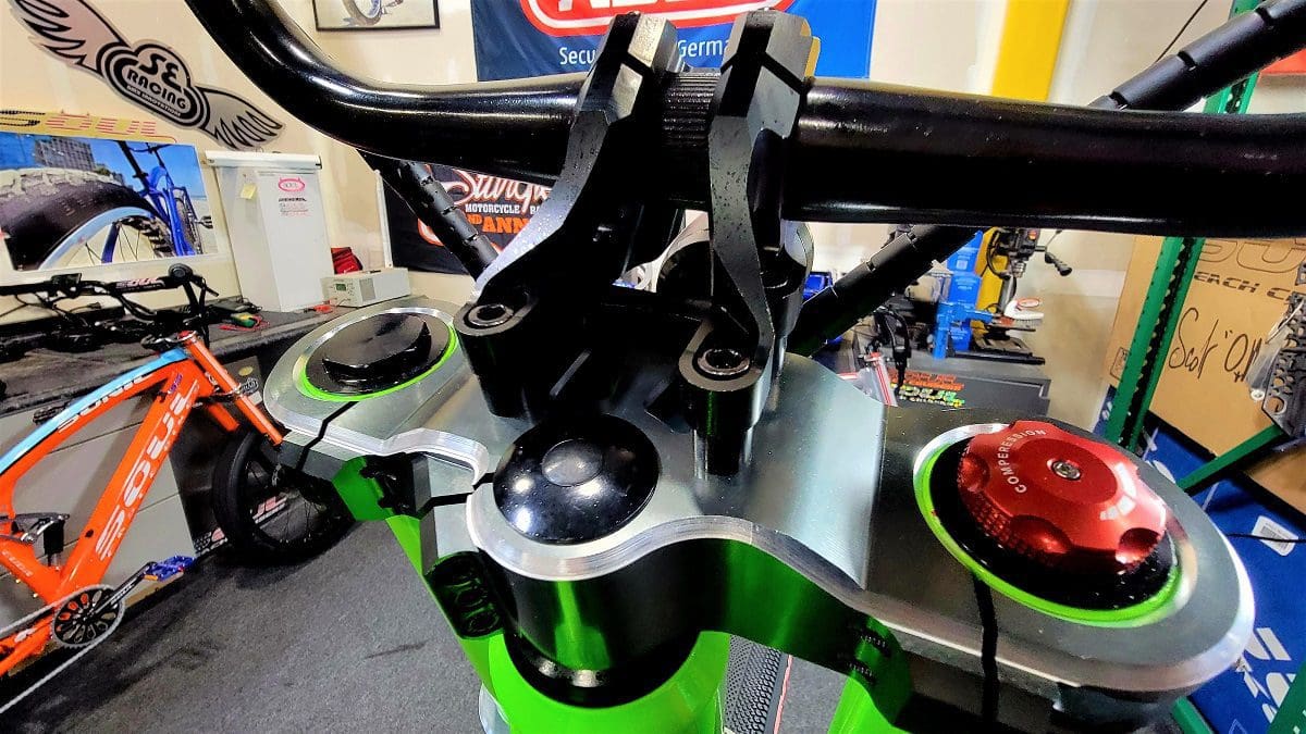 A green and black motorcycle is shown in the background.