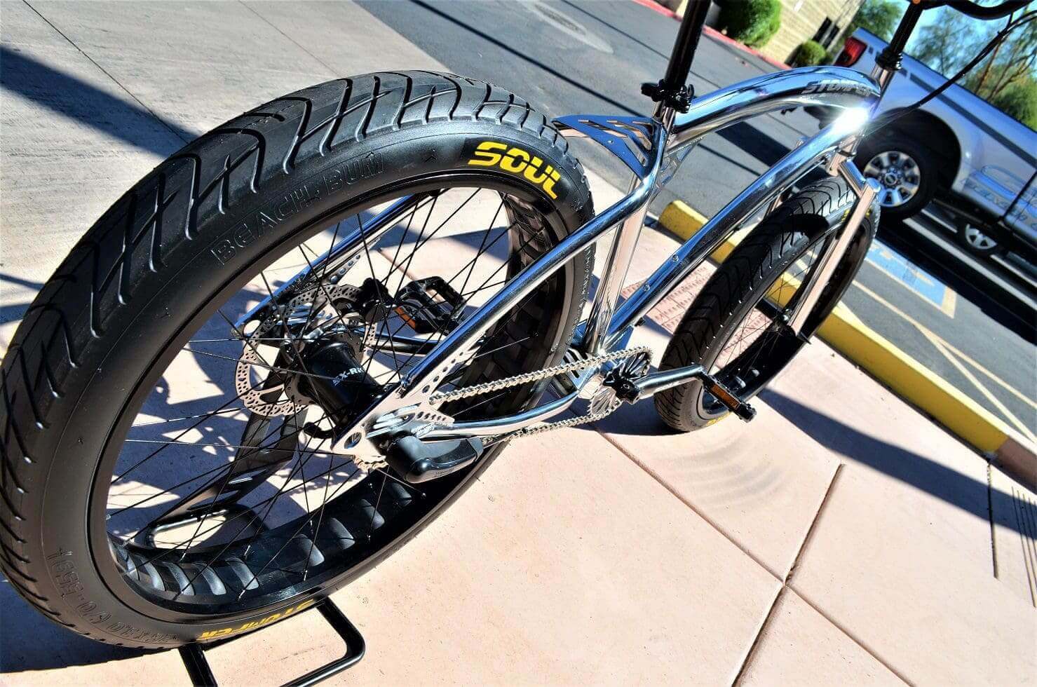 A Soul Stomper Chrome Black is parked on a sidewalk in front of a building.