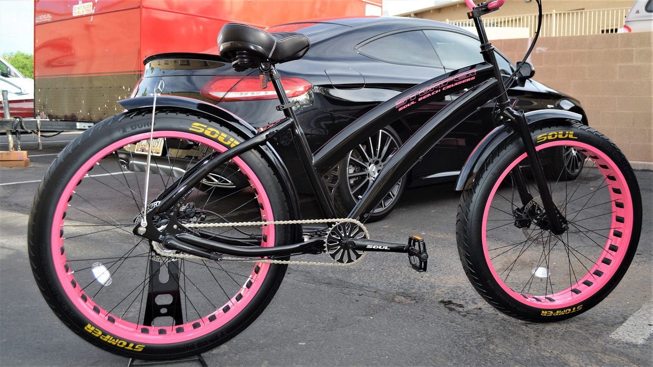 A Ladies Miss Stomper Black out pink parked in a parking lot.