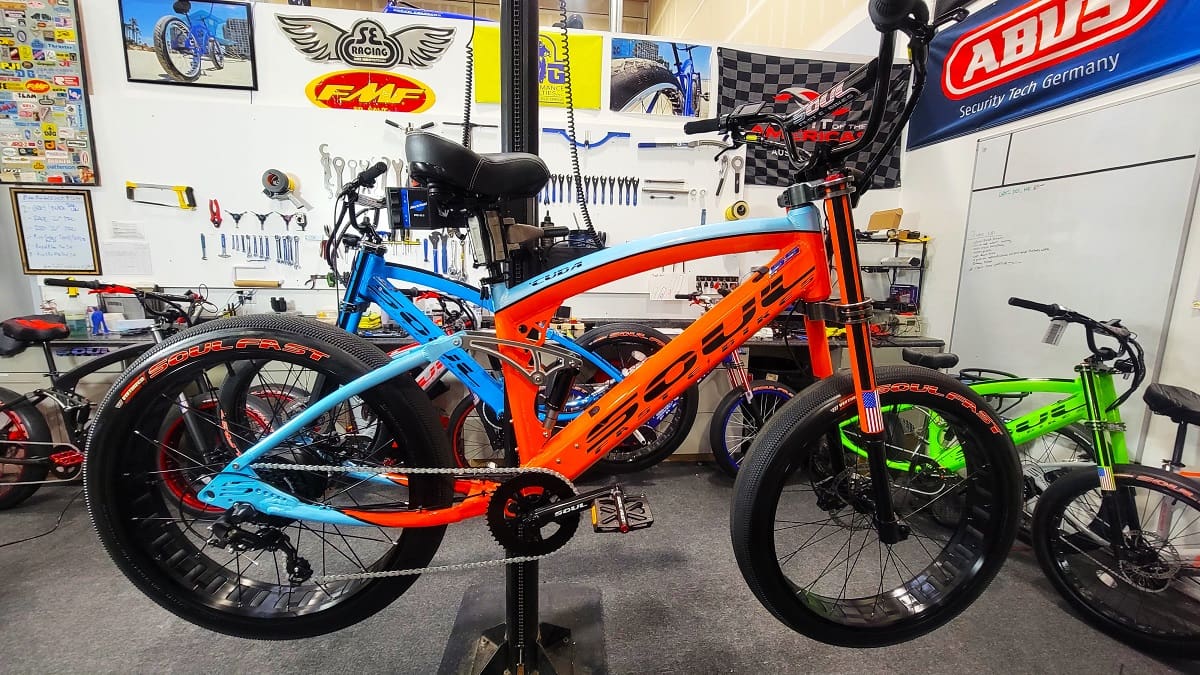 Orange and blue bicycle in a workshop.