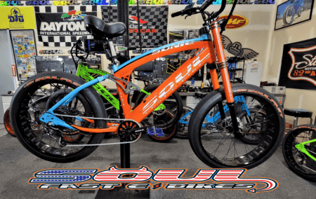 A bicycle is parked in front of some other bikes.