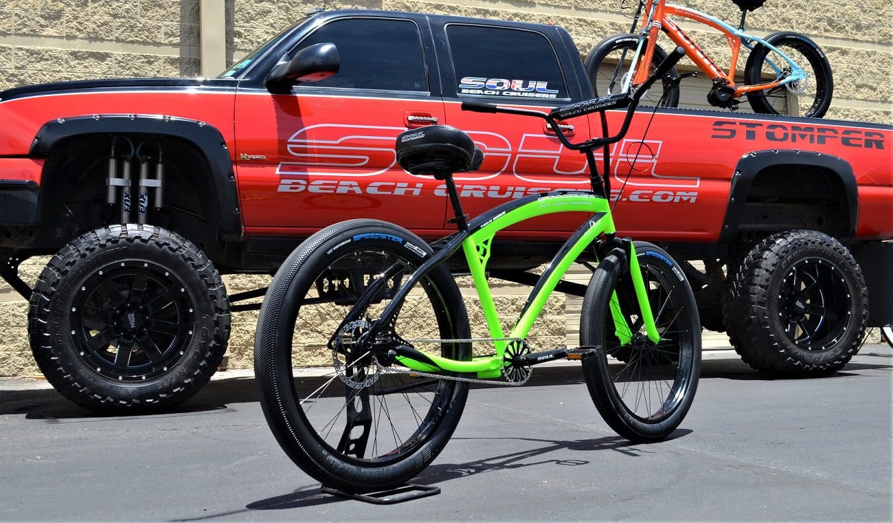 A green bike parked in front of a truck.