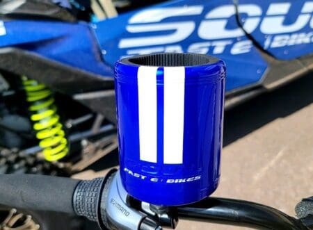 A Soul Embossed Cup Holder - Blue on the handlebars of a motorcycle.