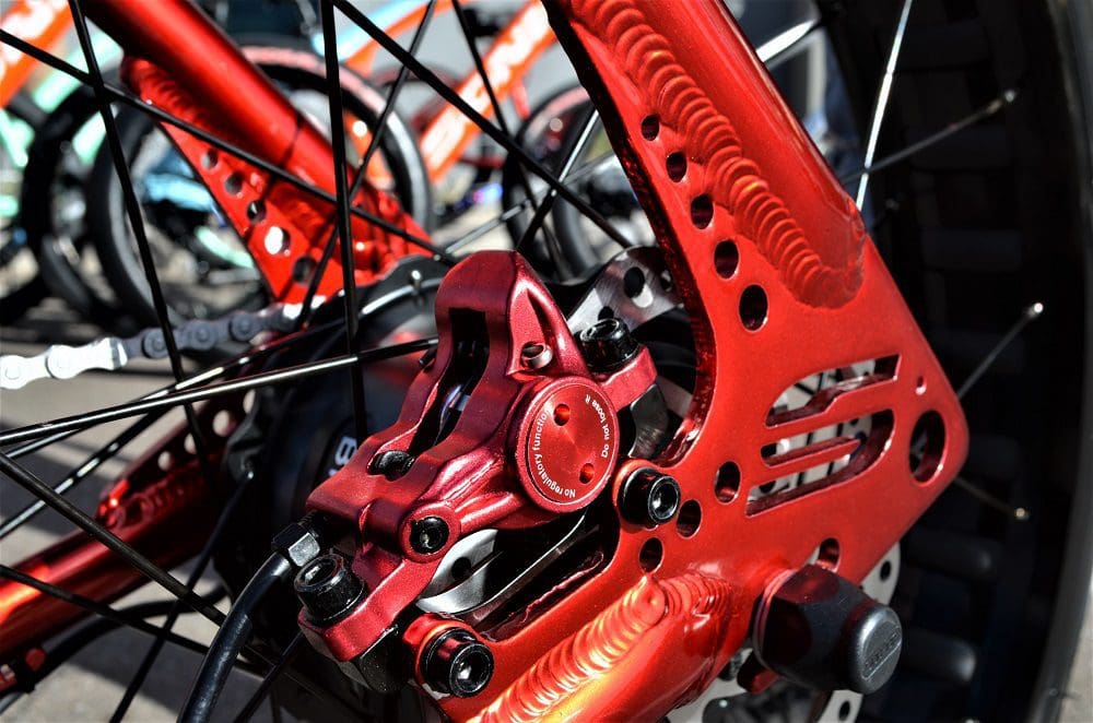 A close up of the front wheel on a red bicycle.