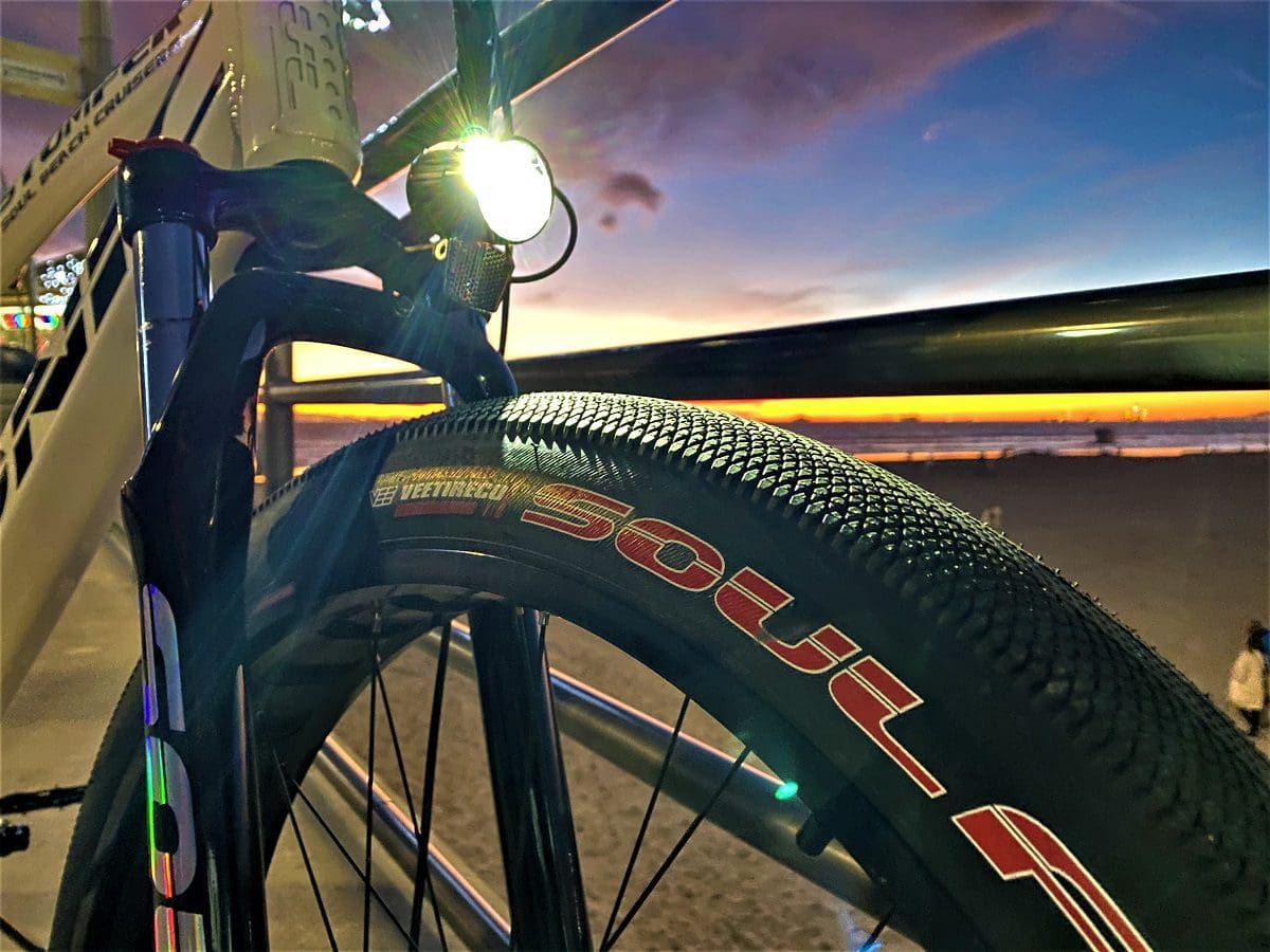 A bicycle tire with the lights on at sunset.