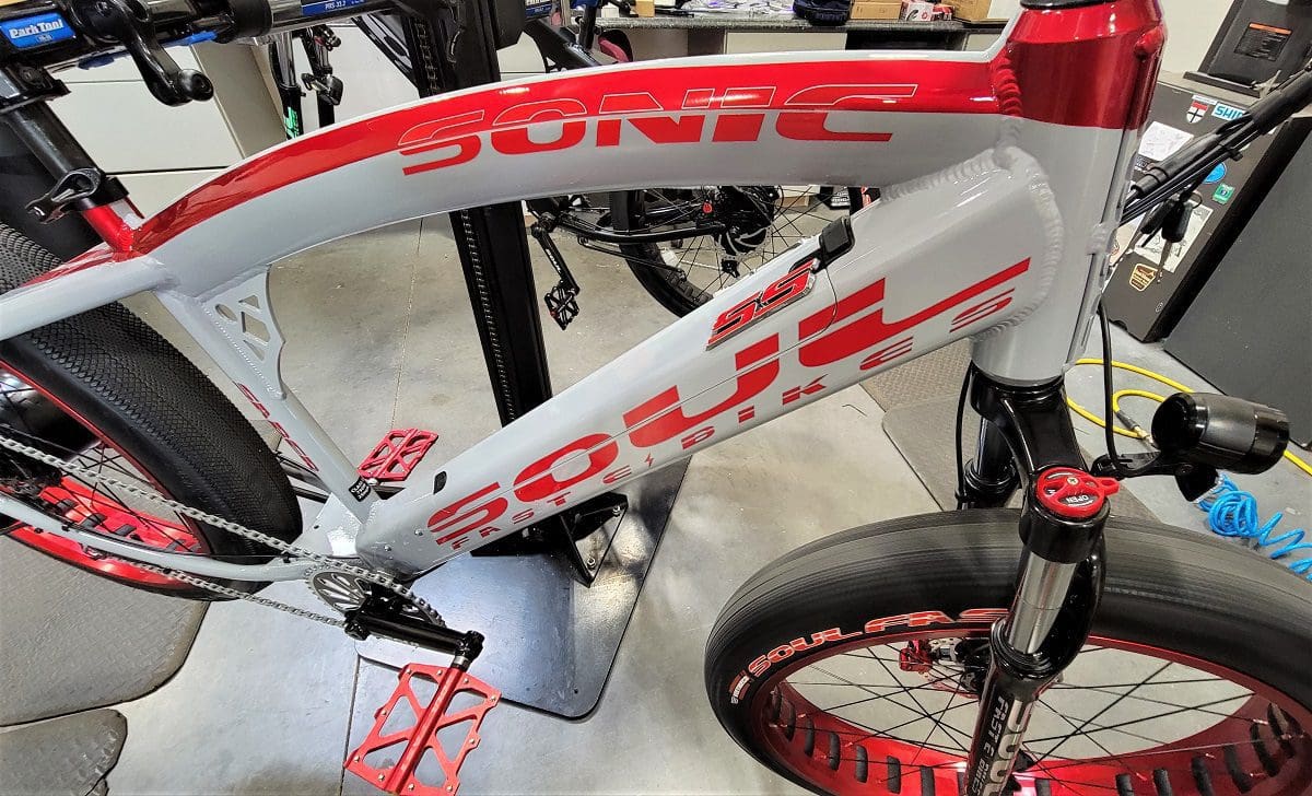 A red and white bike is on display in a room.
