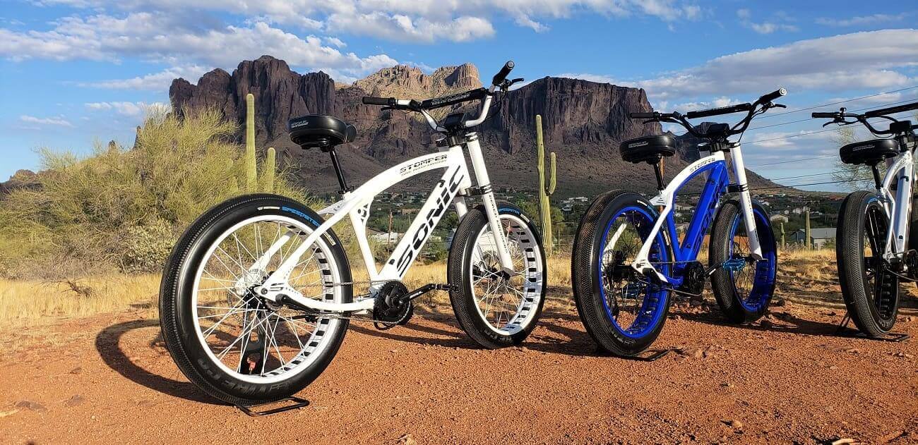 Electric bikes on desert trail with mountains.