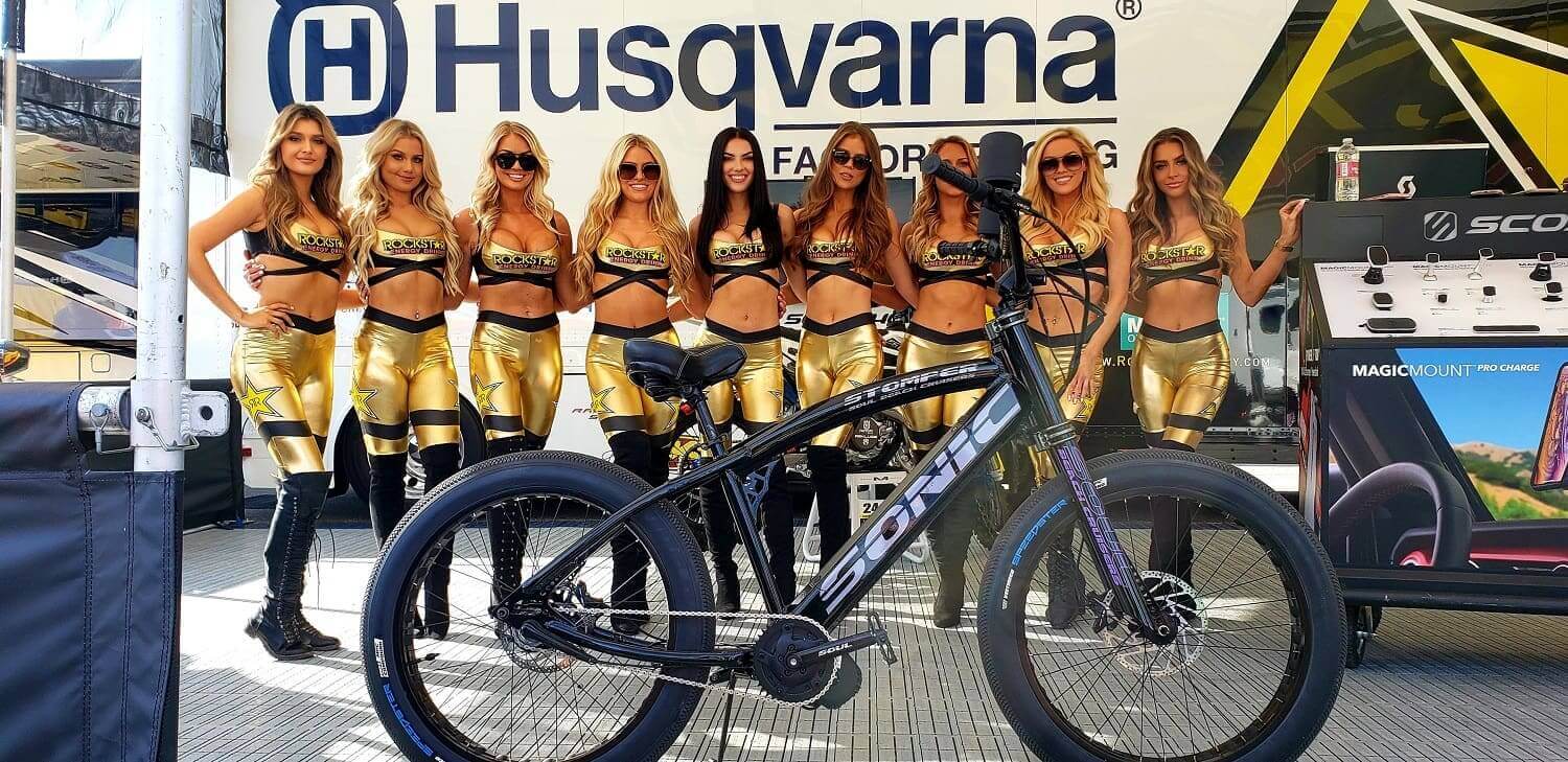 Bicycle in front of women in gold outfits.