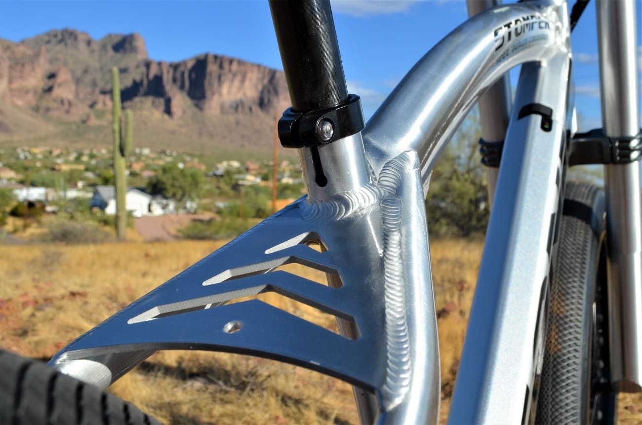 Bicycle frame close-up with mountainous background.