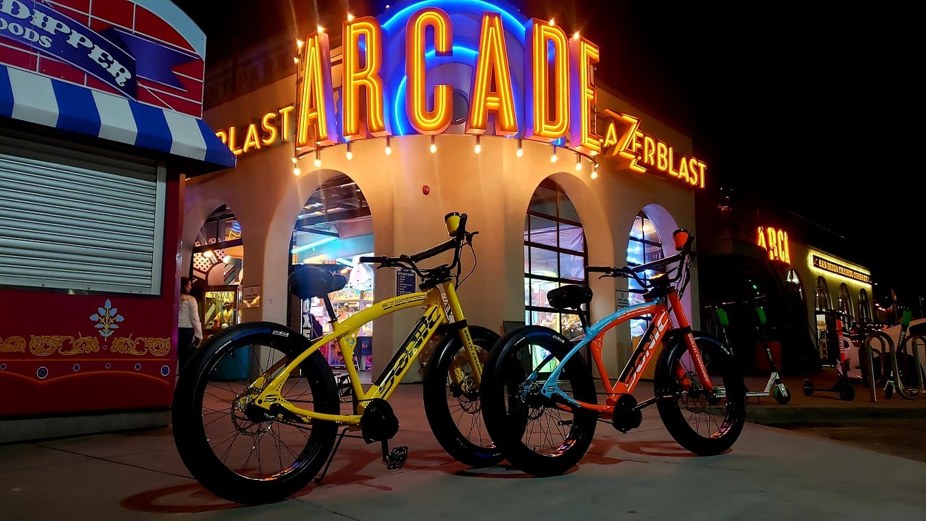 Bicycles parked outside illuminated arcade entrance.