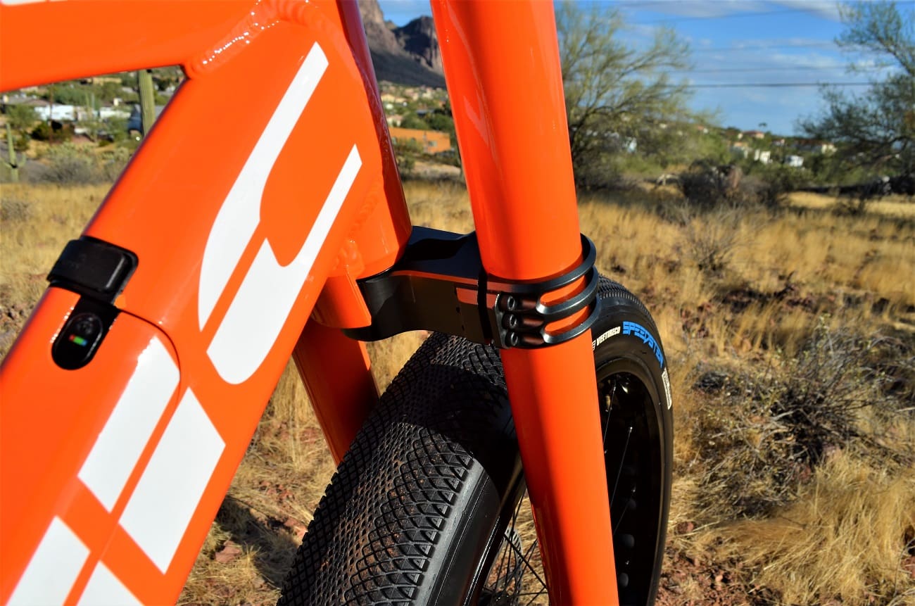 Close-up of orange bicycle frame in desert.