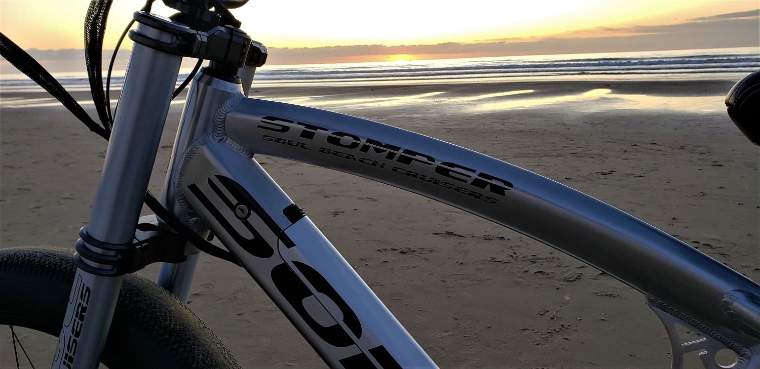 Bicycle on beach during sunset.