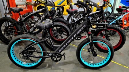 Electric bikes with colorful rims displayed indoors.