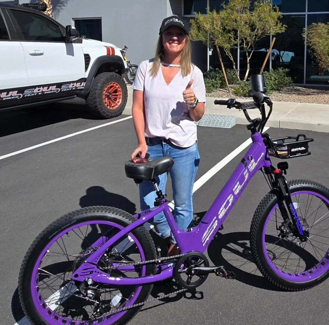 Person with purple electric bike, outdoors.