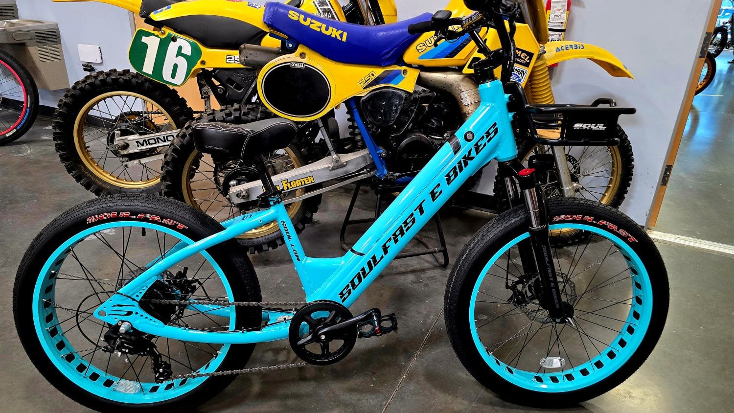 Blue electric bike in front of motorcycles.