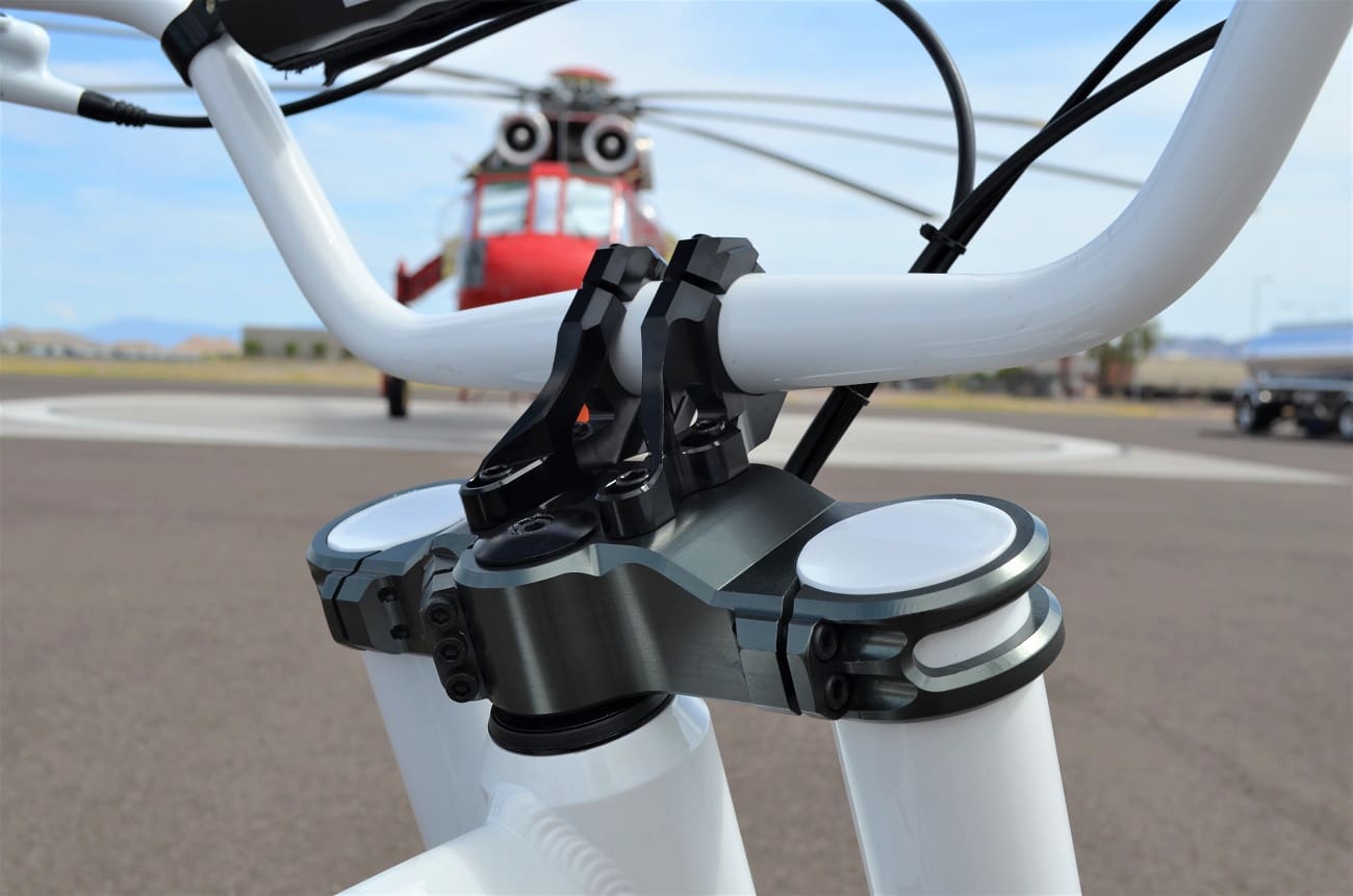 Close-up of bicycle handlebars with helicopter background.