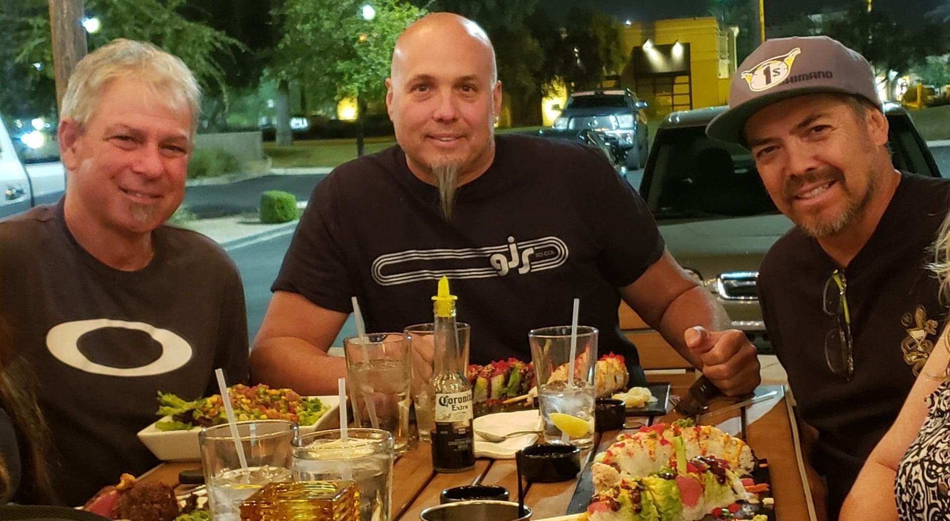 Three men enjoying a meal together at a restaurant, discussing the latest models of SOULFAST EBIKES.