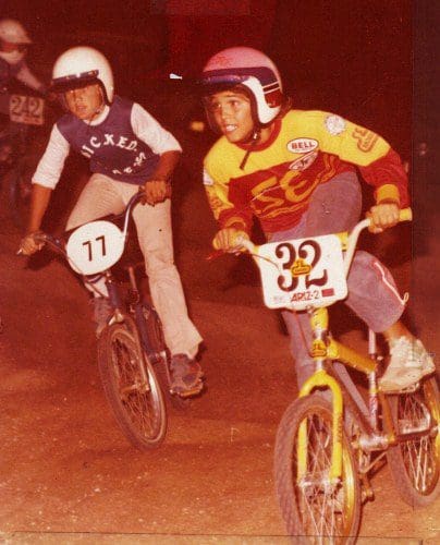 Two young BMX riders racing on a dirt track, competitor 232 leading with intense focus, showcasing the dynamic capabilities of SOULFAST EBIKES.