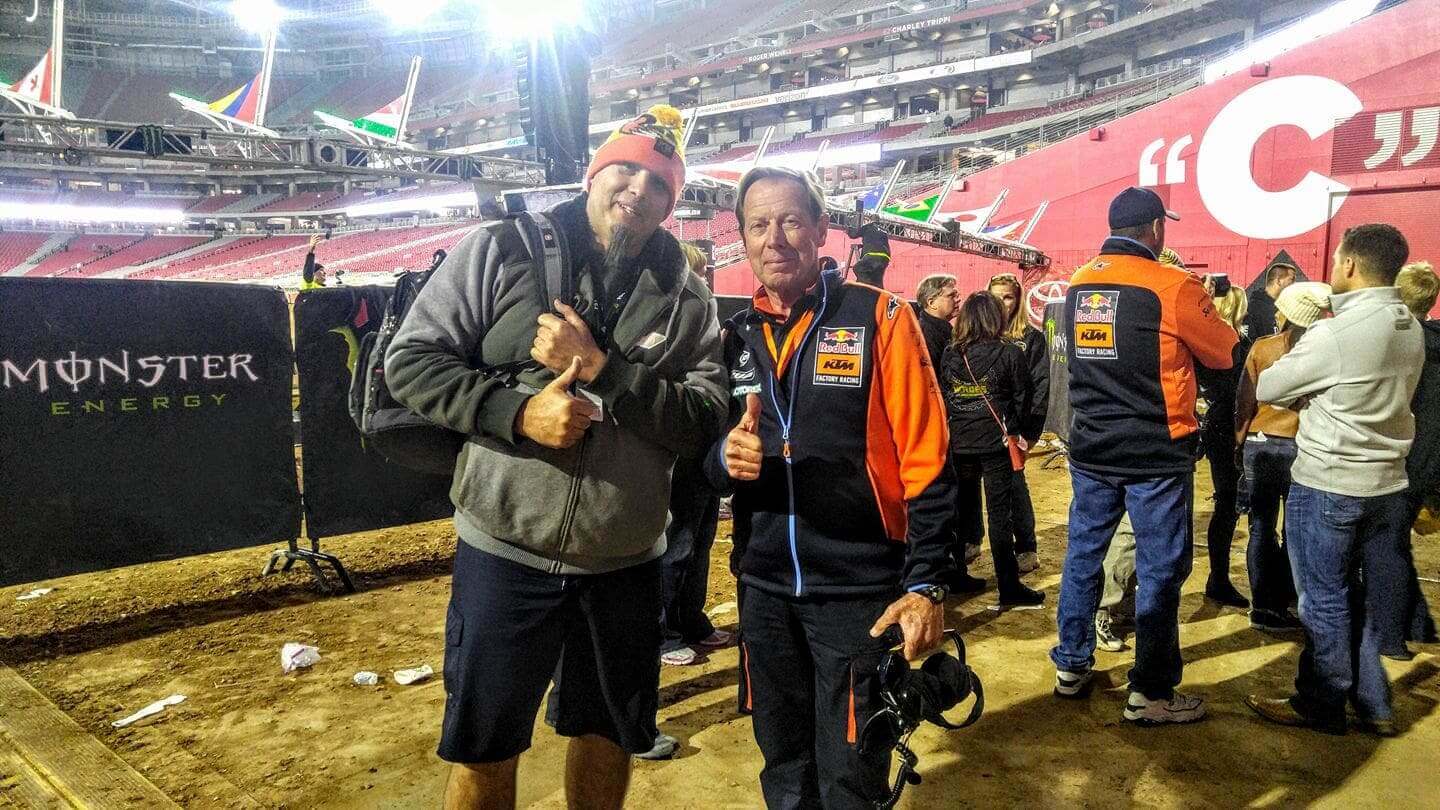 Two individuals posing for a photo at a stadium event with "SOULFAST EBIKES" branding visible in the background.