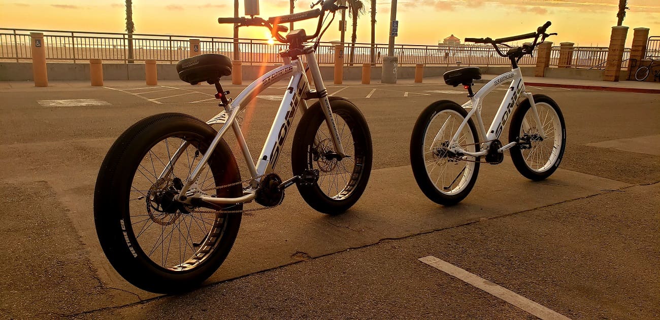Two bicycles parked at sunset beach.