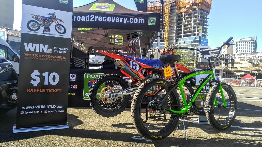 Motorcycle raffle display with bicycles outside.