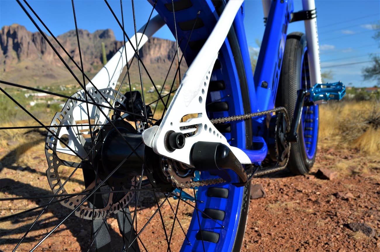 Mountain bike wheel and gears in desert terrain.