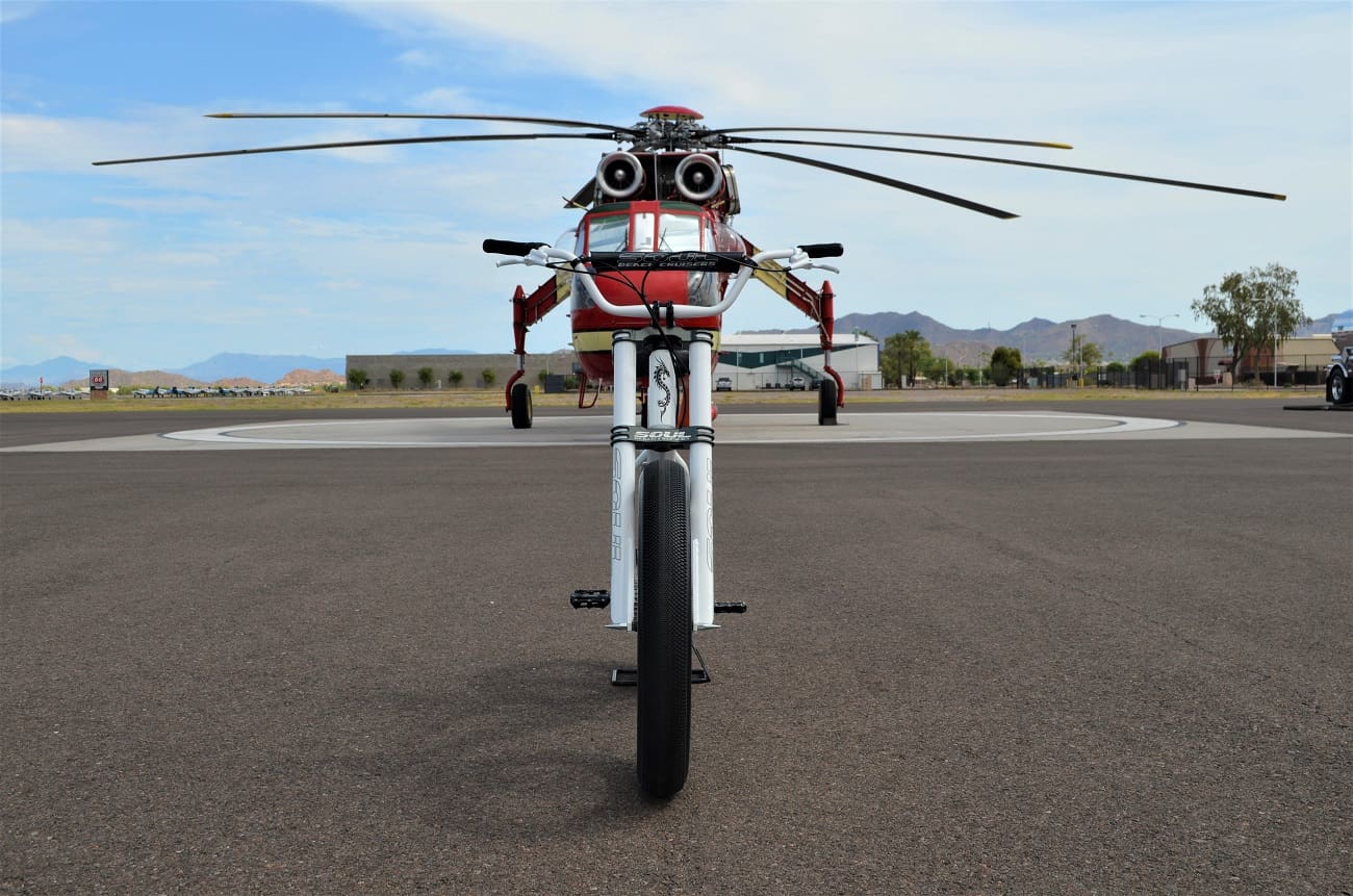 Red helicopter on a tarmac, front view.