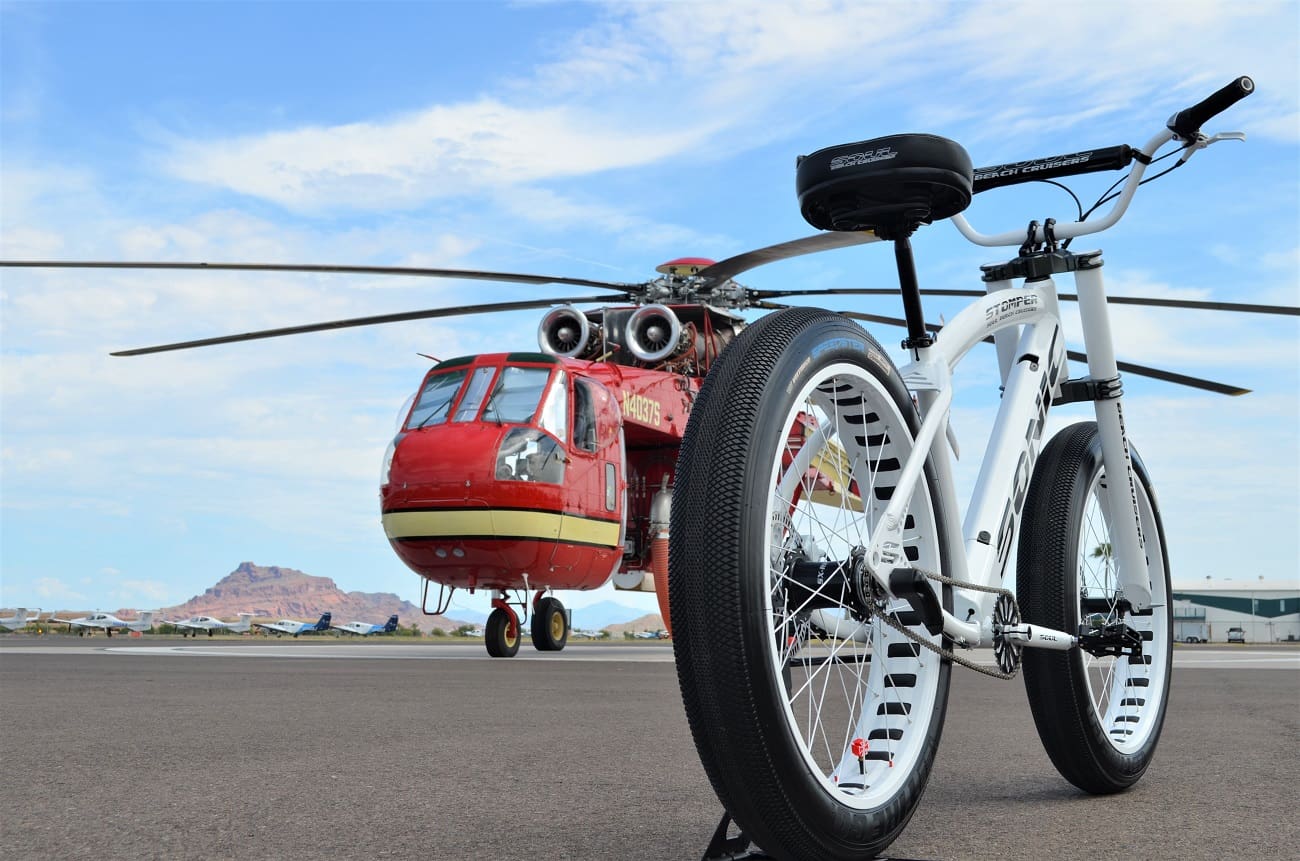 Bicycle and red helicopter on airfield.