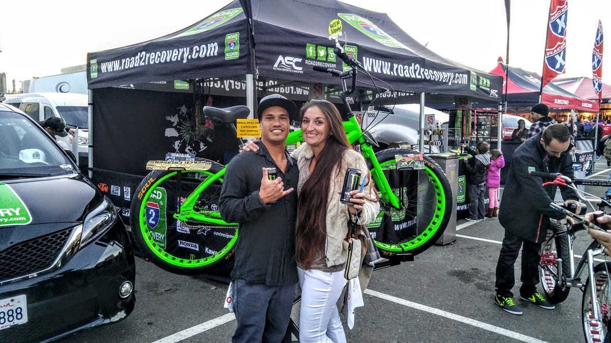 Couple posing at cycling event booth.