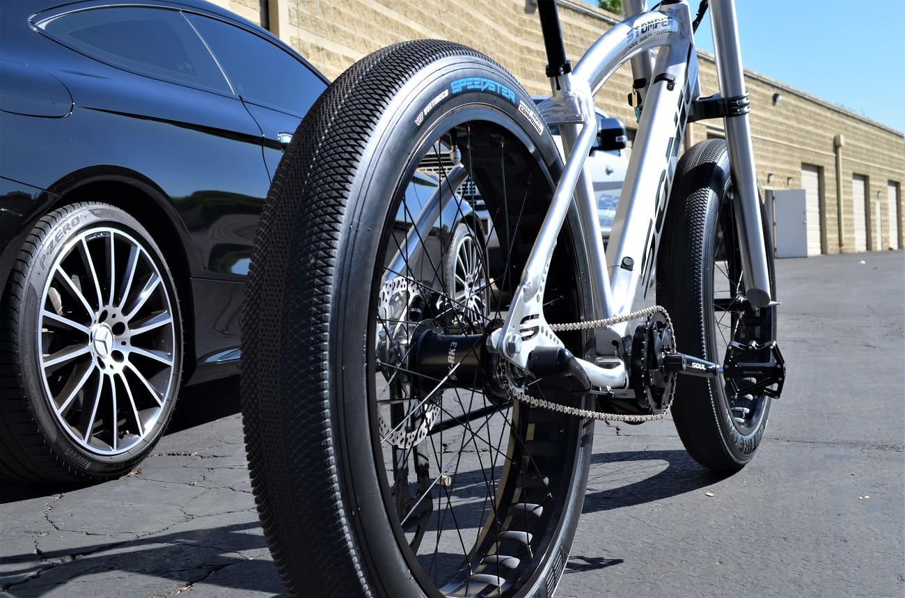 Bicycle and car parked on pavement.