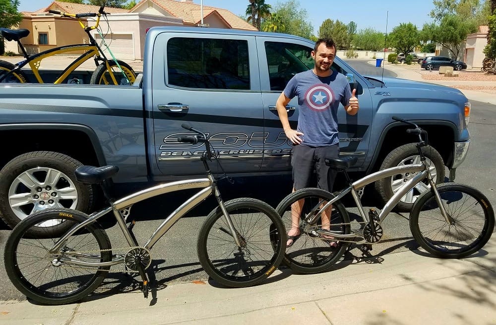 Man with bicycles beside a pickup truck.